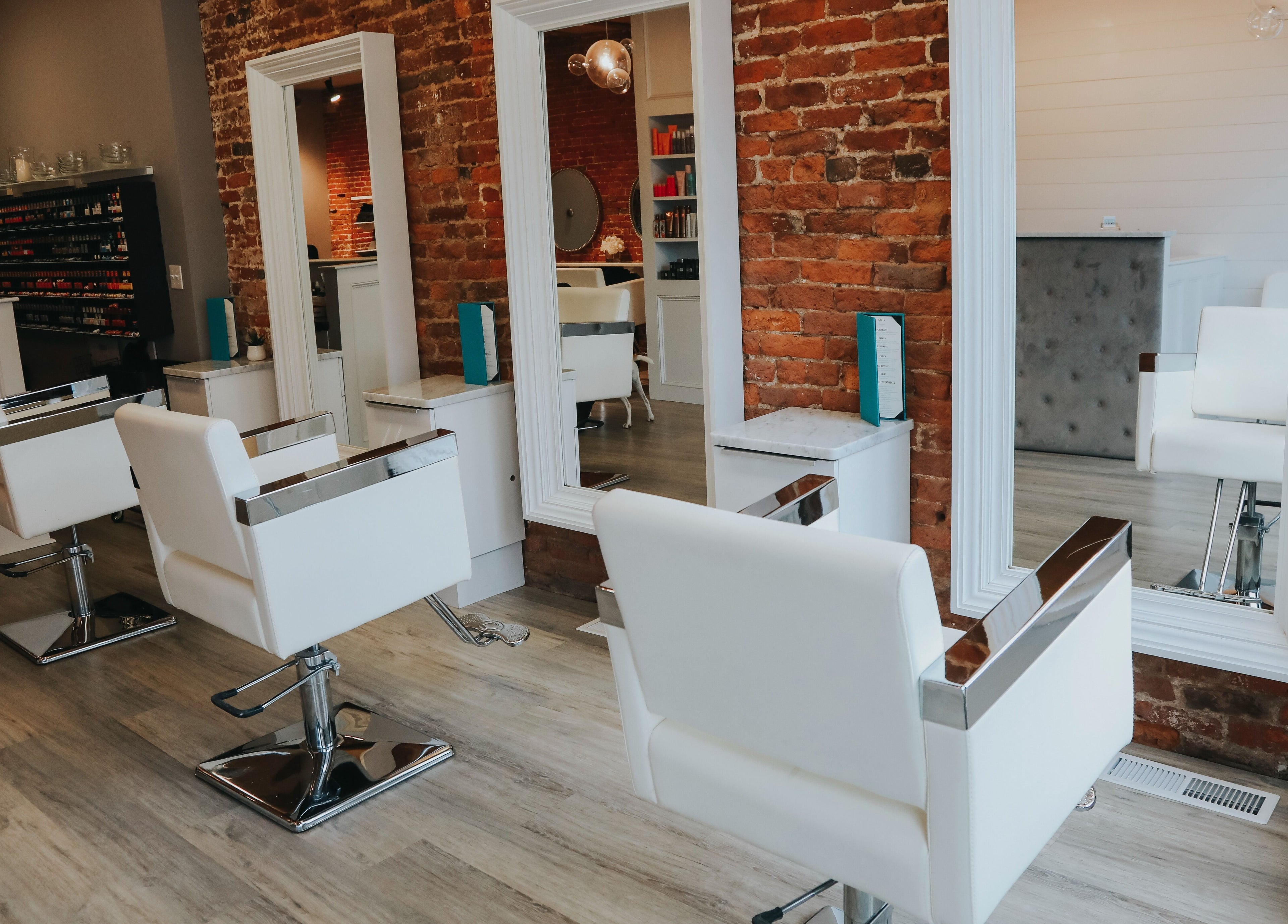 Modern styling chairs and mirrors at French Twist Salon in Newburyport, Massachusetts, US featuring exposed brick.