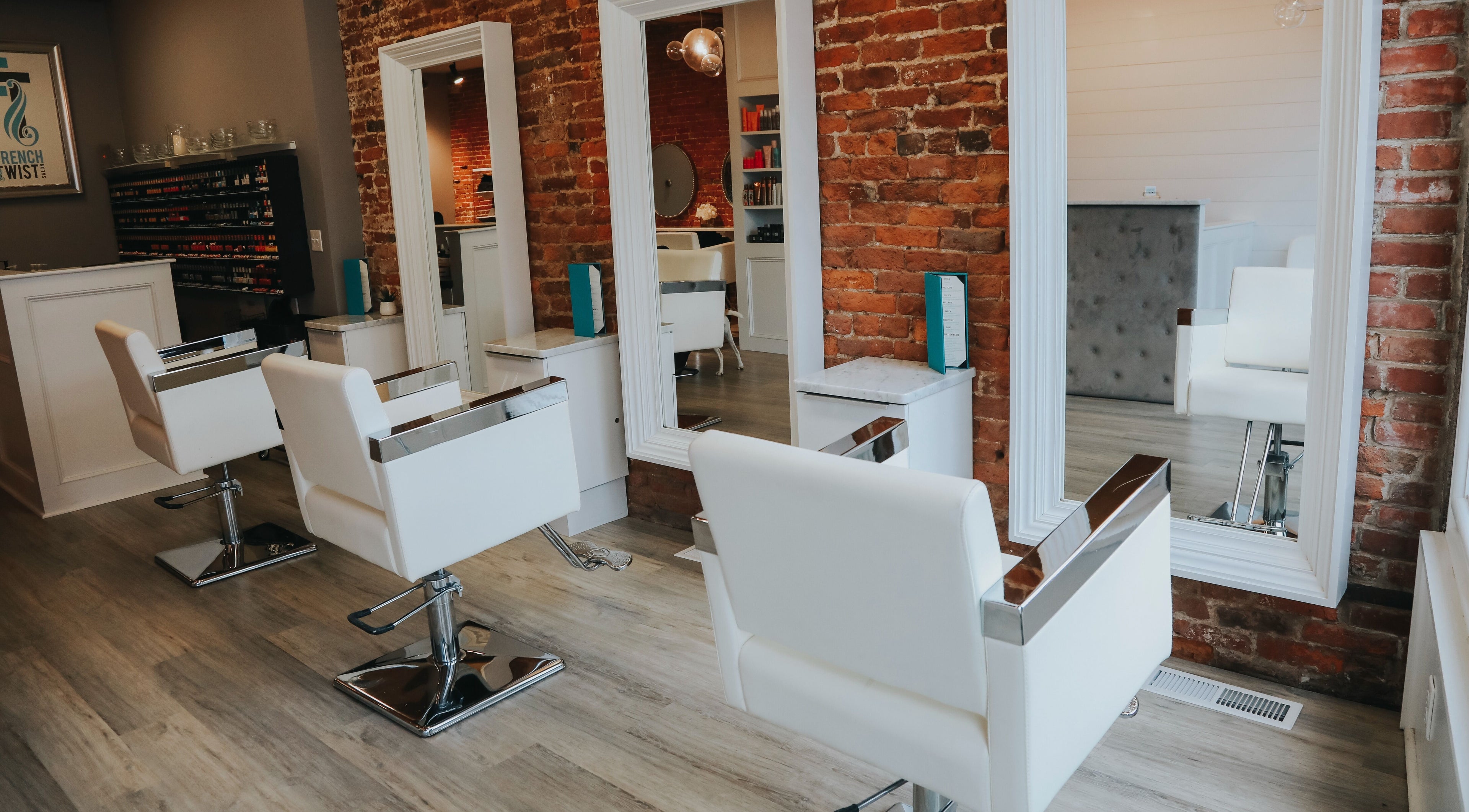 Modern styling chairs and mirrors at French Twist Salon in Newburyport, Massachusetts, US featuring exposed brick.