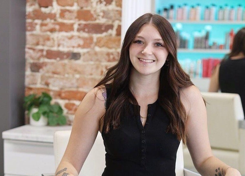 Friendly stylist at French Twist Salon, Newburyport, Massachusetts, US, with products and chic décor.