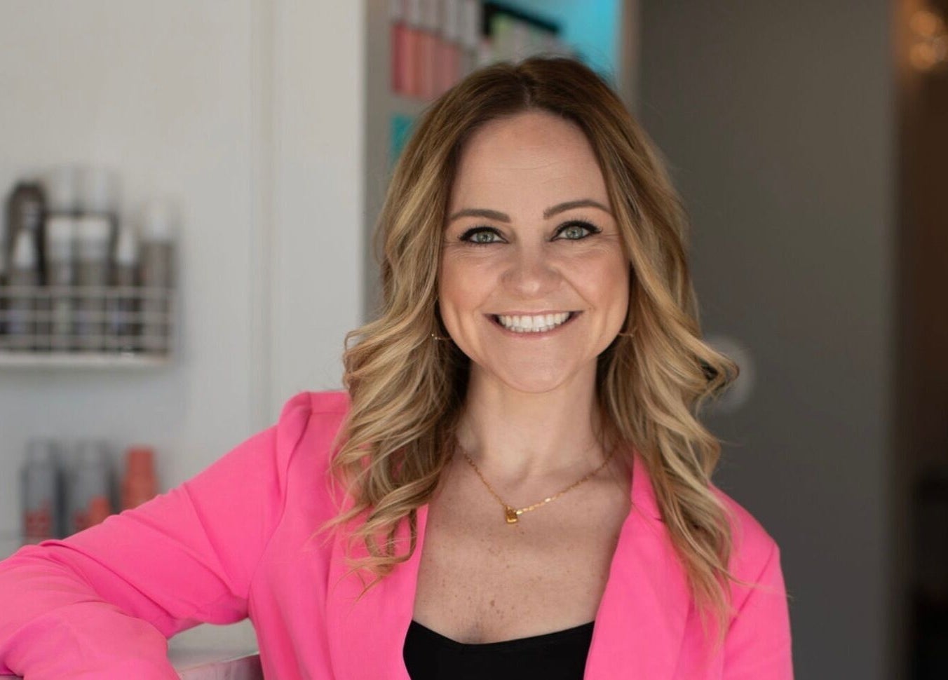 Smiling stylist in pink jacket at French Twist Salon, Newburyport, Massachusetts, US.