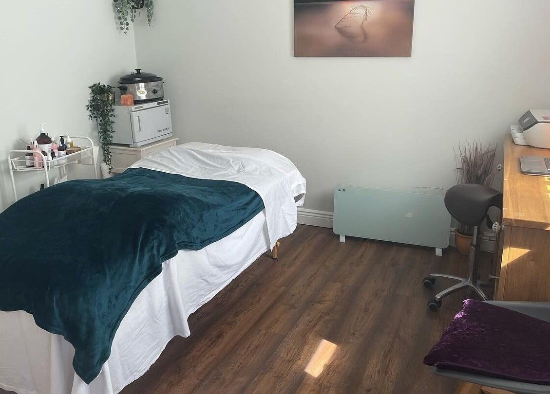 Cozy treatment room at Renew Therapies Sandyford, Sandyford, County Dublin, IE with massage bed and desk.