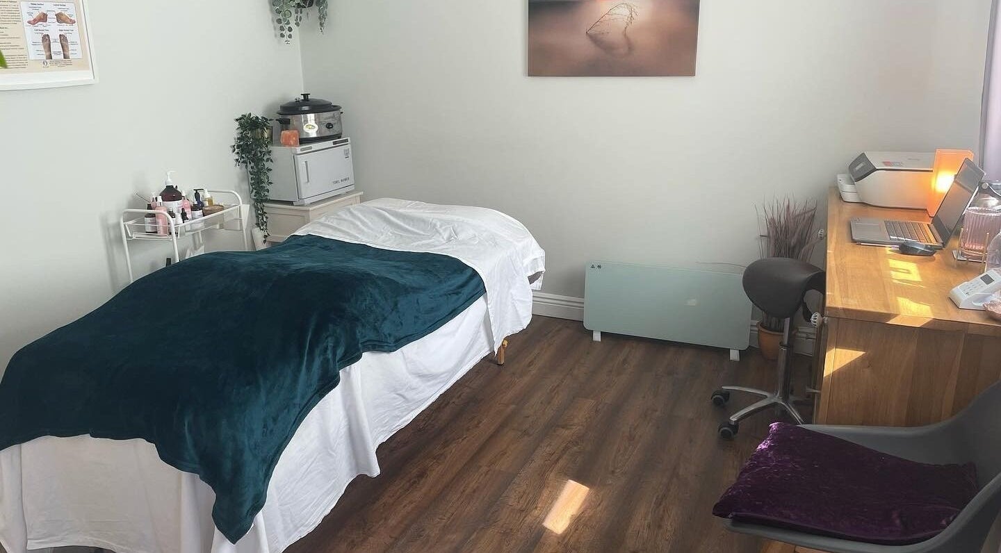 Cozy treatment room at Renew Therapies Sandyford, Sandyford, County Dublin, IE with massage bed and desk.