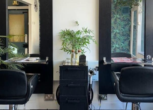 Modern hairstyling station at Jane Edwards, London, England, GB with sleek black chairs and lush plants.