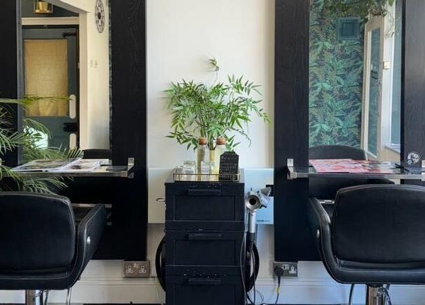 Modern hairstyling station at Jane Edwards, London, England, GB with sleek black chairs and lush plants.
