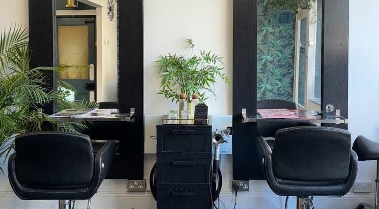 Modern hairstyling station at Jane Edwards, London, England, GB with sleek black chairs and lush plants.