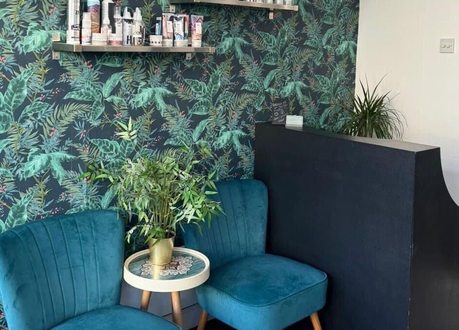 Stylish lounge area at Jane Edwards, London, England featuring teal chairs and lush green decor.