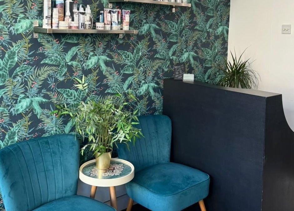 Stylish lounge area at Jane Edwards, London, England featuring teal chairs and lush green decor.