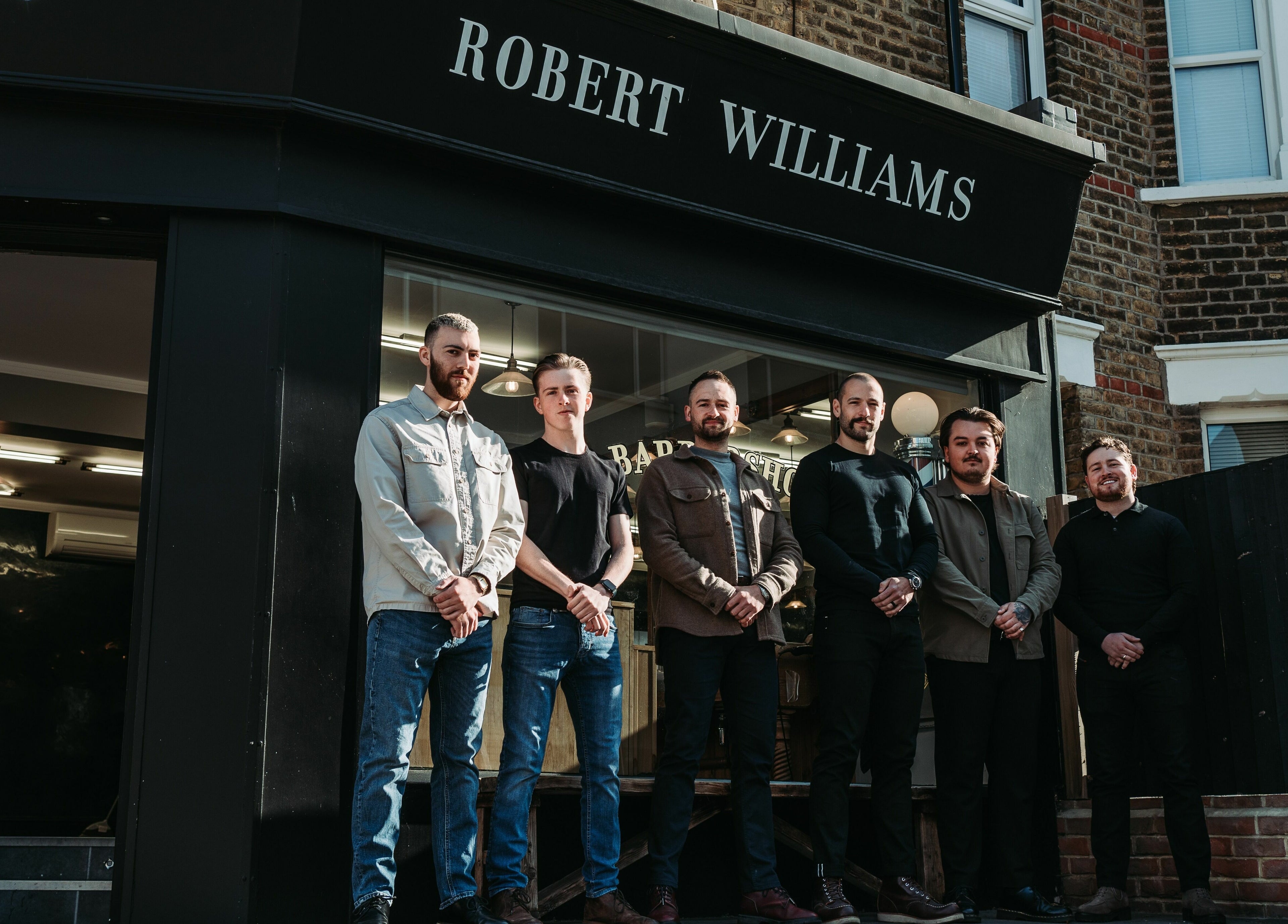 Team of barbers outside Robert Williams Barbershop, Southend-on-Sea, England, GB on a sunny day.