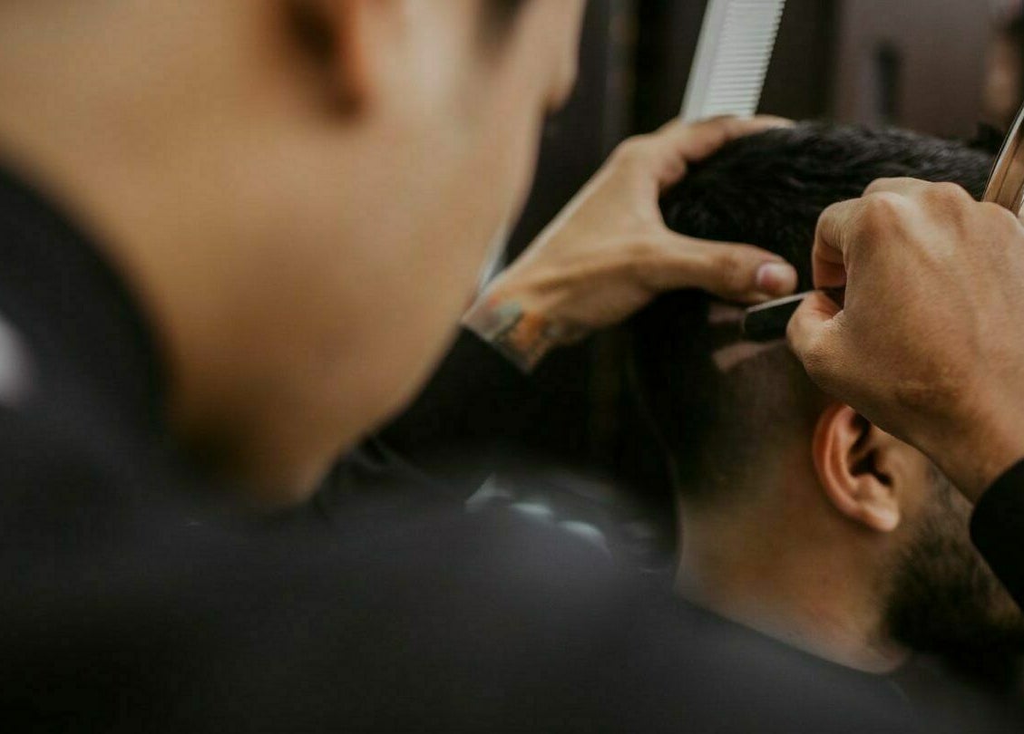 A barber expertly shapes a client's hair at Mr Snips Heswall, Heswall, England, GB.