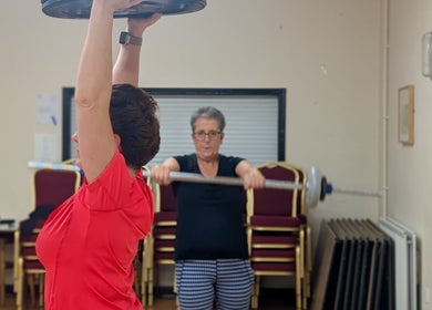 People lifting weights at Kerrie’s PMA fitness, Tenby, Wales, GB, boosting strength and wellness.