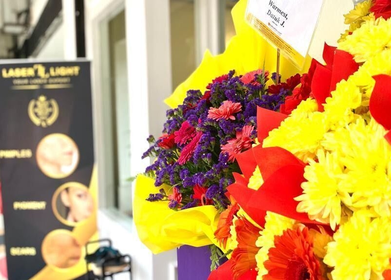 Bright floral arrangement at Laser Light Skin Centre Shah Alam, Selangor, MY, with elegant signage in view.