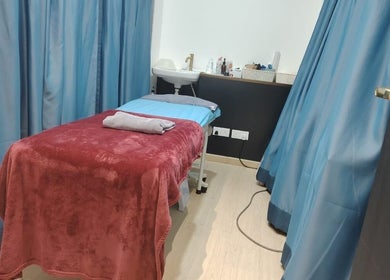 Cozy treatment room at Laser Light Skin Centre (Cheras Permaisuri), Kuala Lumpur, MY with a massage bed and blue curtains.