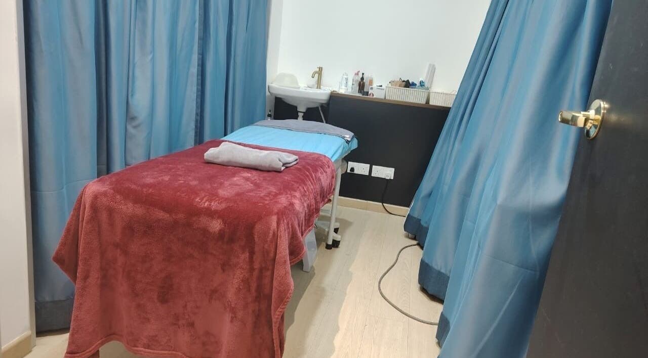 Cozy treatment room at Laser Light Skin Centre (Cheras Permaisuri), Kuala Lumpur, MY with a massage bed and blue curtains.