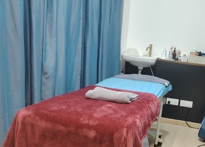 Treatment room at Laser Light Skin Centre (Kuantan) in Kuantan, Pahang, MY with a cozy bed and soothing blue curtains.