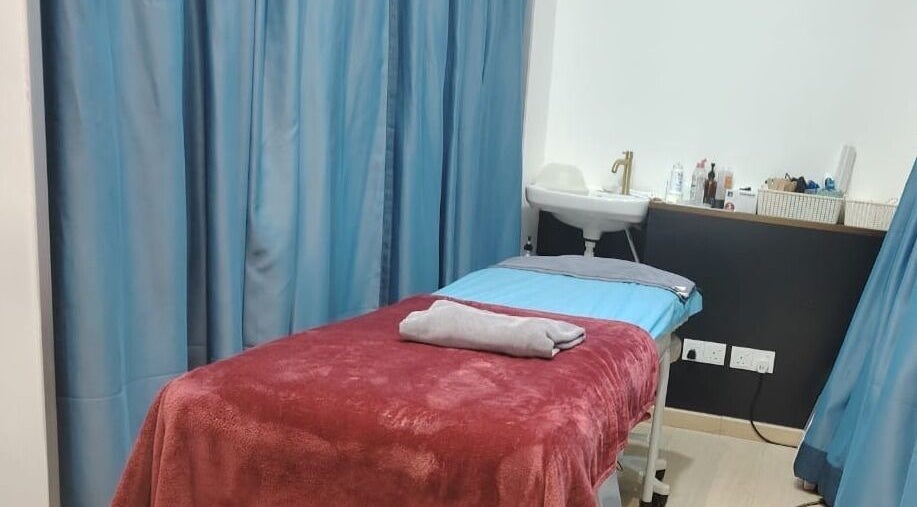 Treatment room at Laser Light Skin Centre (Kuantan) in Kuantan, Pahang, MY with a cozy bed and soothing blue curtains.
