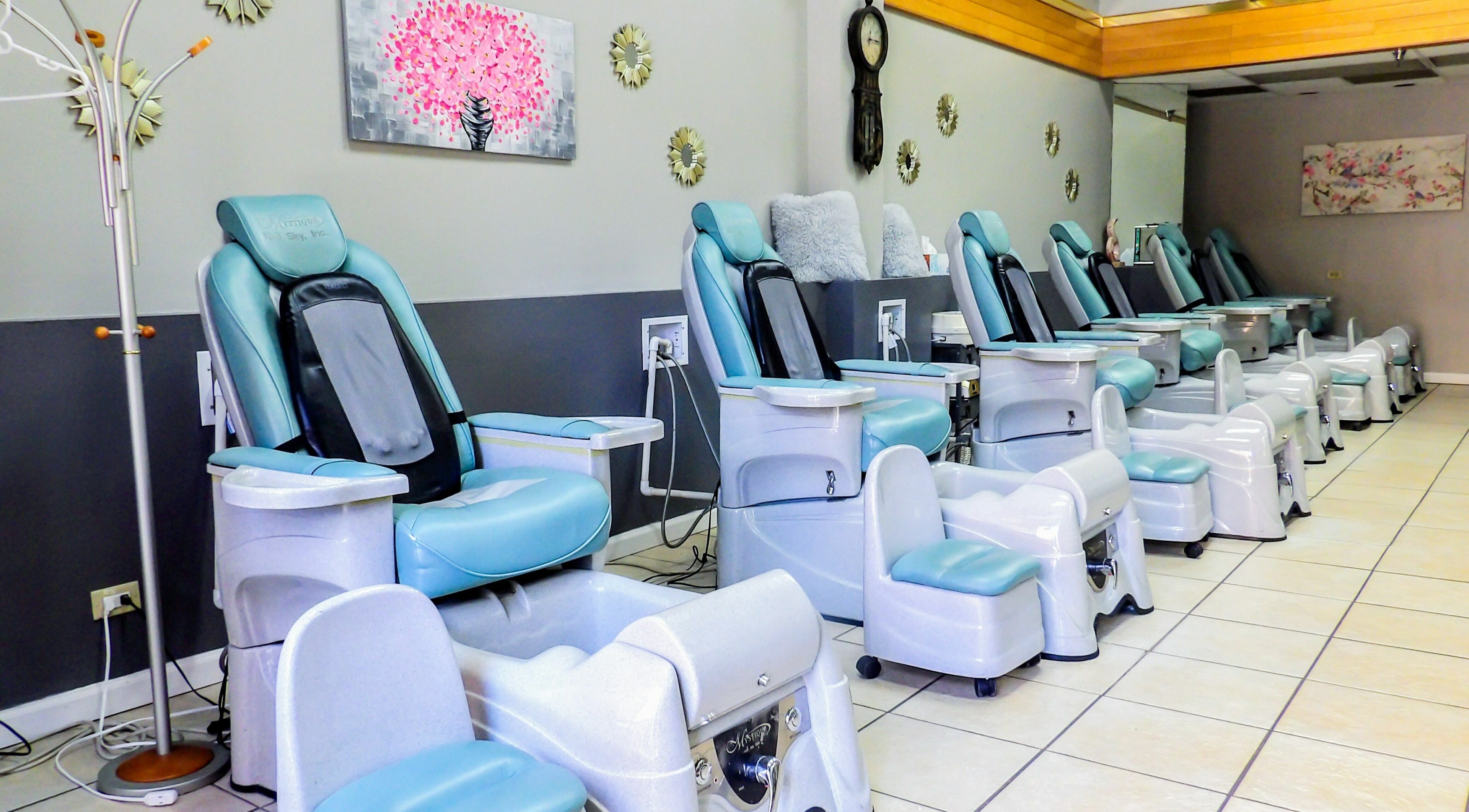 Rows of pedicure chairs at Flawless Nail Bar, Denver, Colorado, US, showcasing a serene environment.