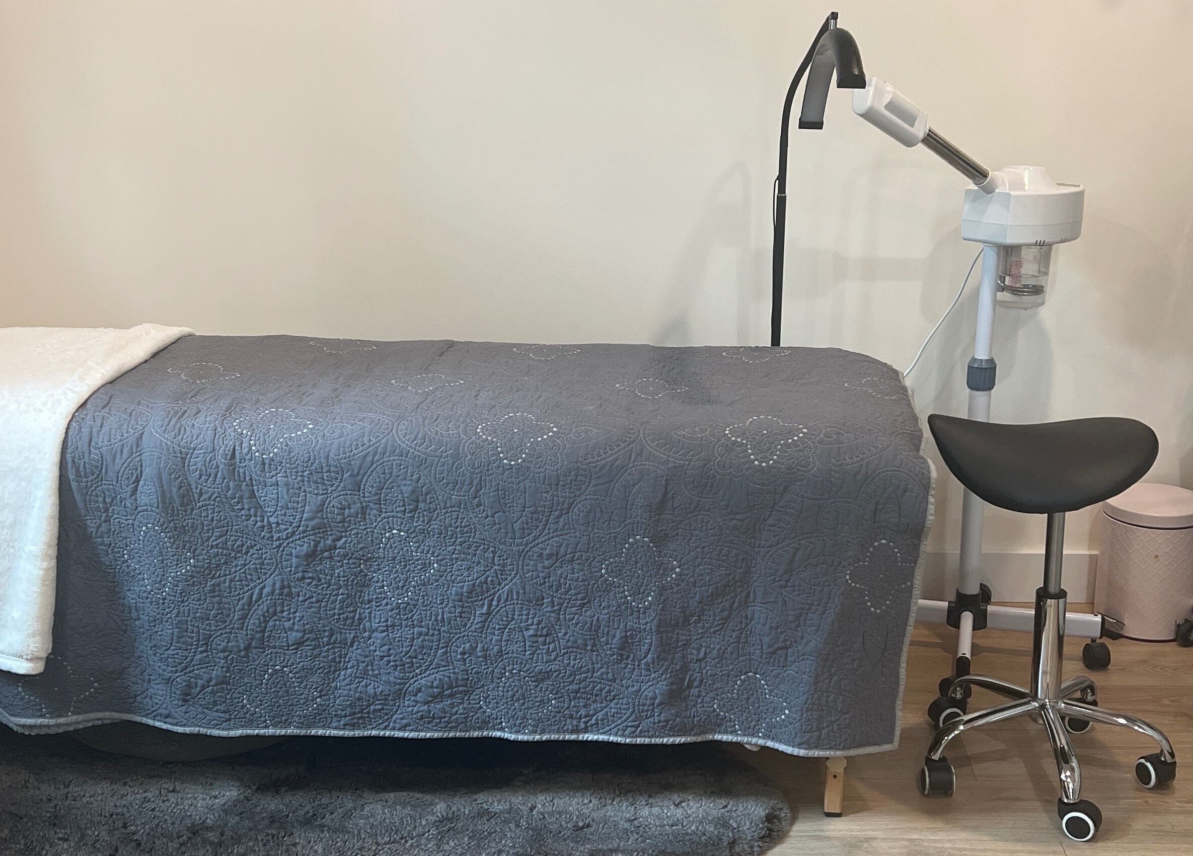 Tranquil treatment room at 771 Beaute’ Bar, Buxton, Maine, US, featuring a plush bed and modern equipment.