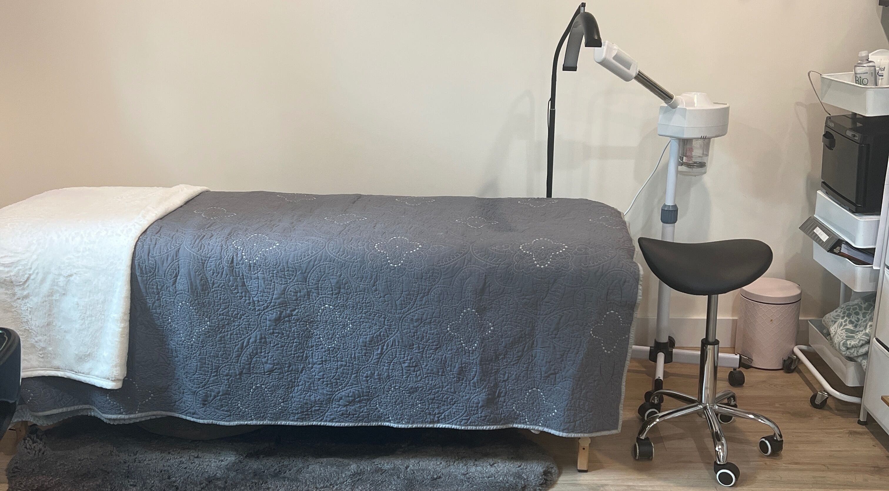 Tranquil treatment room at 771 Beaute’ Bar, Buxton, Maine, US, featuring a plush bed and modern equipment.