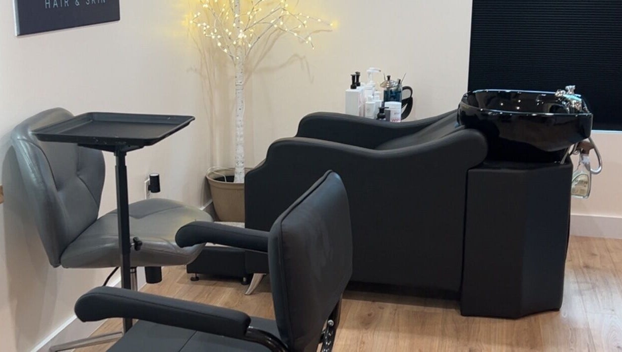 Modern salon station at 771 Beaute’ Bar, Buxton, Maine with comfortable seating and a sleek wash basin.