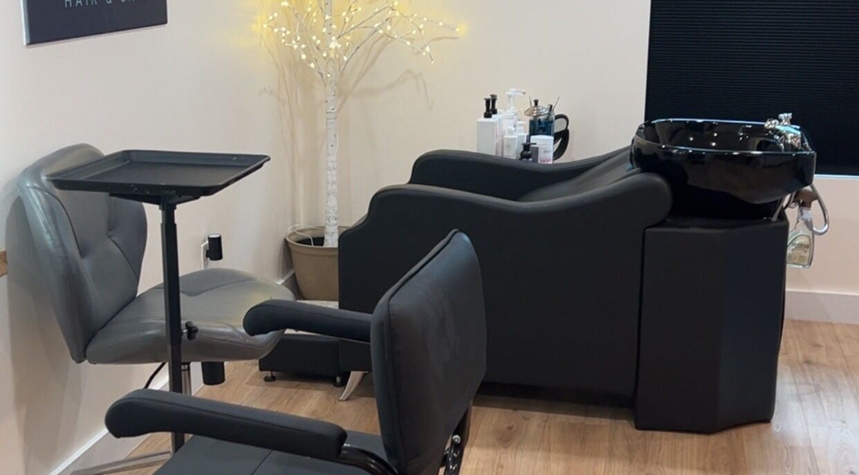 Modern salon station at 771 Beaute’ Bar, Buxton, Maine with comfortable seating and a sleek wash basin.