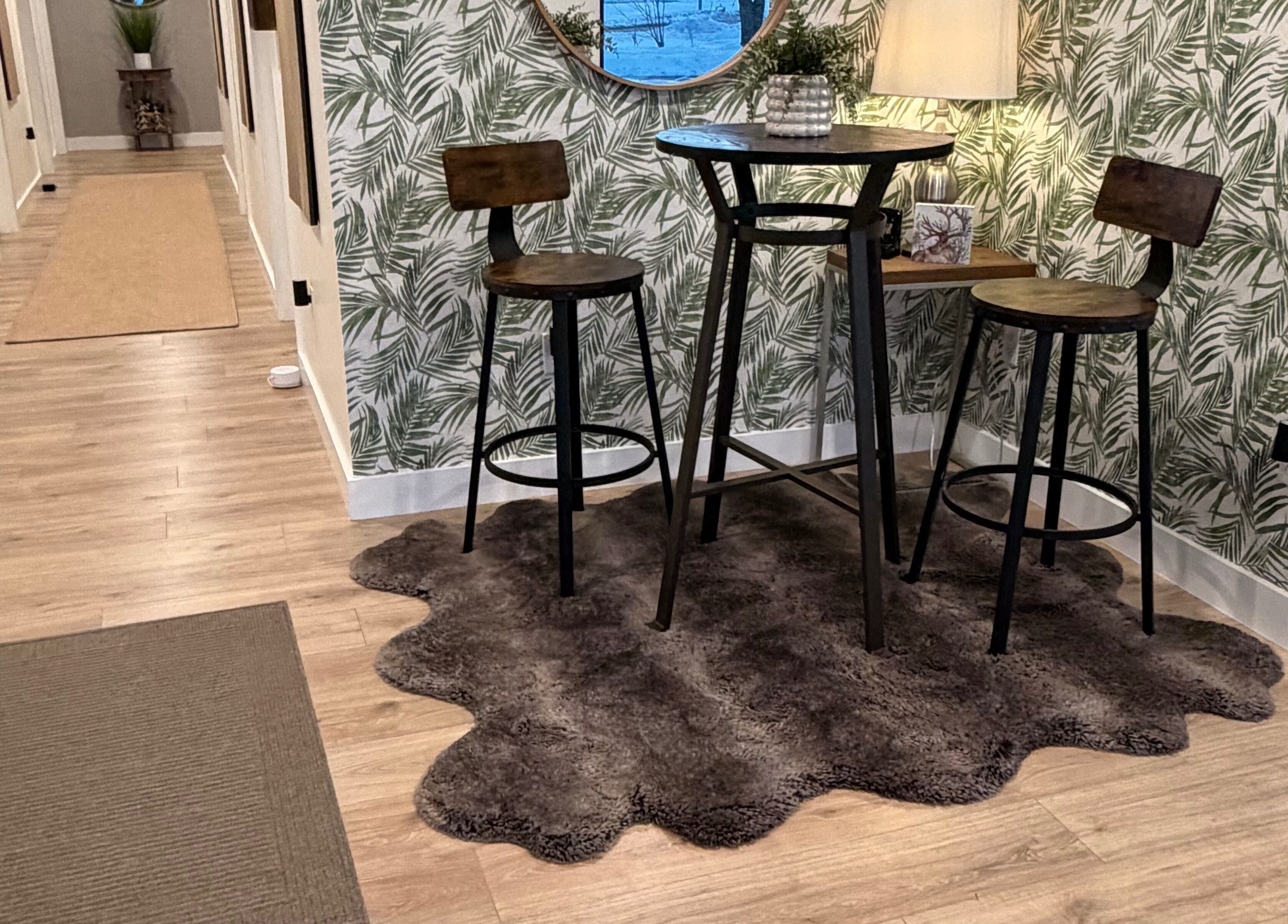 Chic seating area at 771 Beaute’ Bar, Buxton, Maine, US featuring wooden stools and tropical wallpaper.