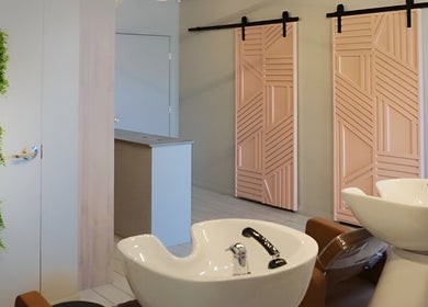 Stylish salon interior with pink doors and green decor at Studio29, Edmonton, Alberta, CA.
