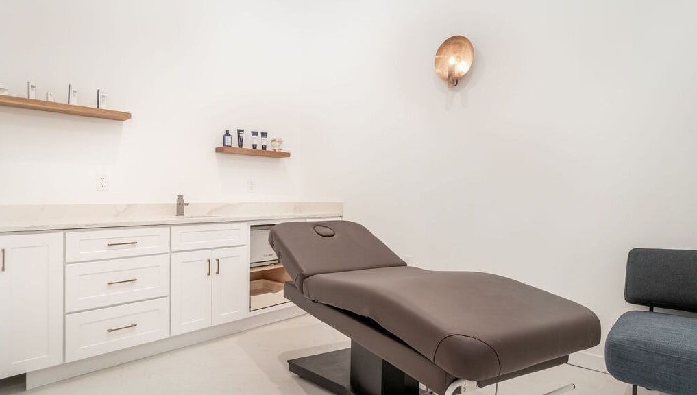 Relaxing treatment room at Merum Face Bar in Allen, Texas, US with a modern spa bed and minimalist decor.