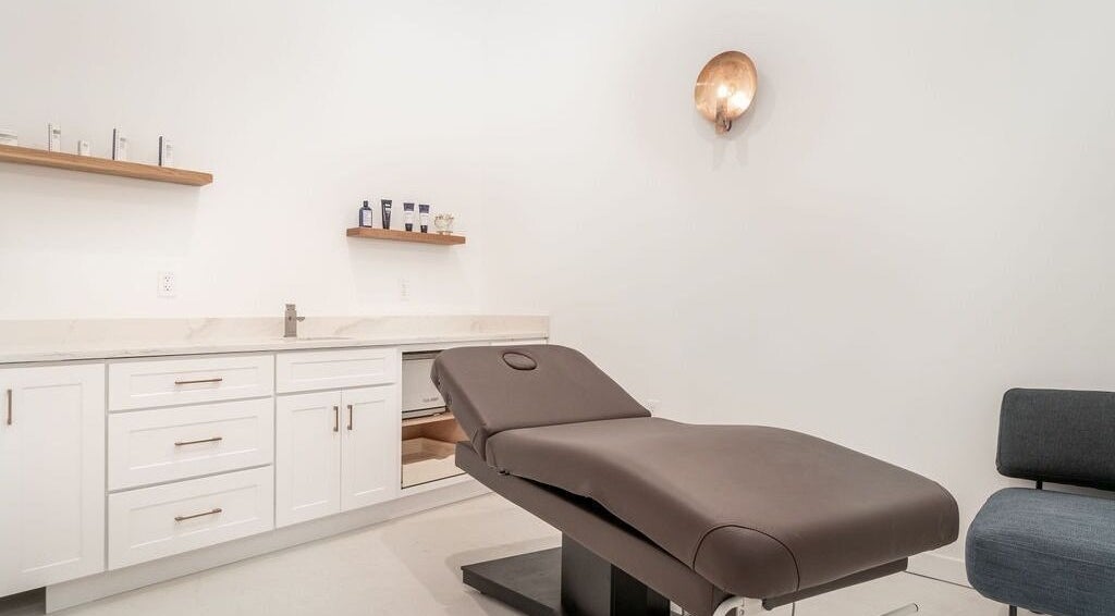 Relaxing treatment room at Merum Face Bar in Allen, Texas, US with a modern spa bed and minimalist decor.