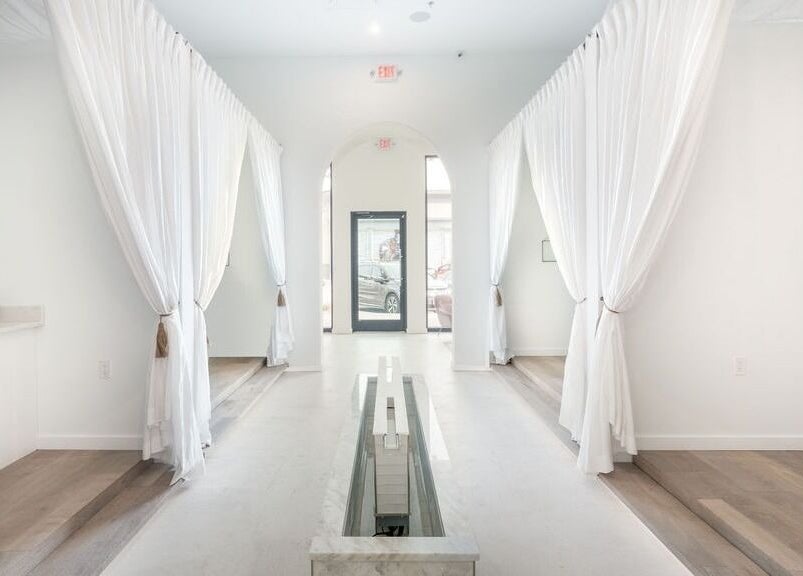Elegant interior view of Merum Face Bar, Allen, Texas, US, featuring white drapes and modern design.