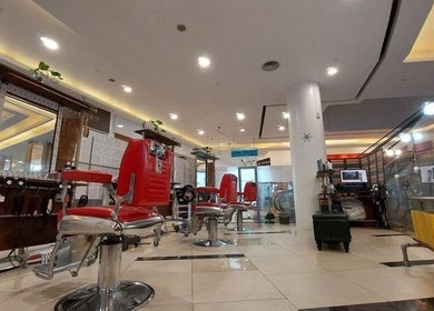 Modern interior of Rich & Ridge Hair Gallery in Singapore, SG, featuring sleek red salon chairs.