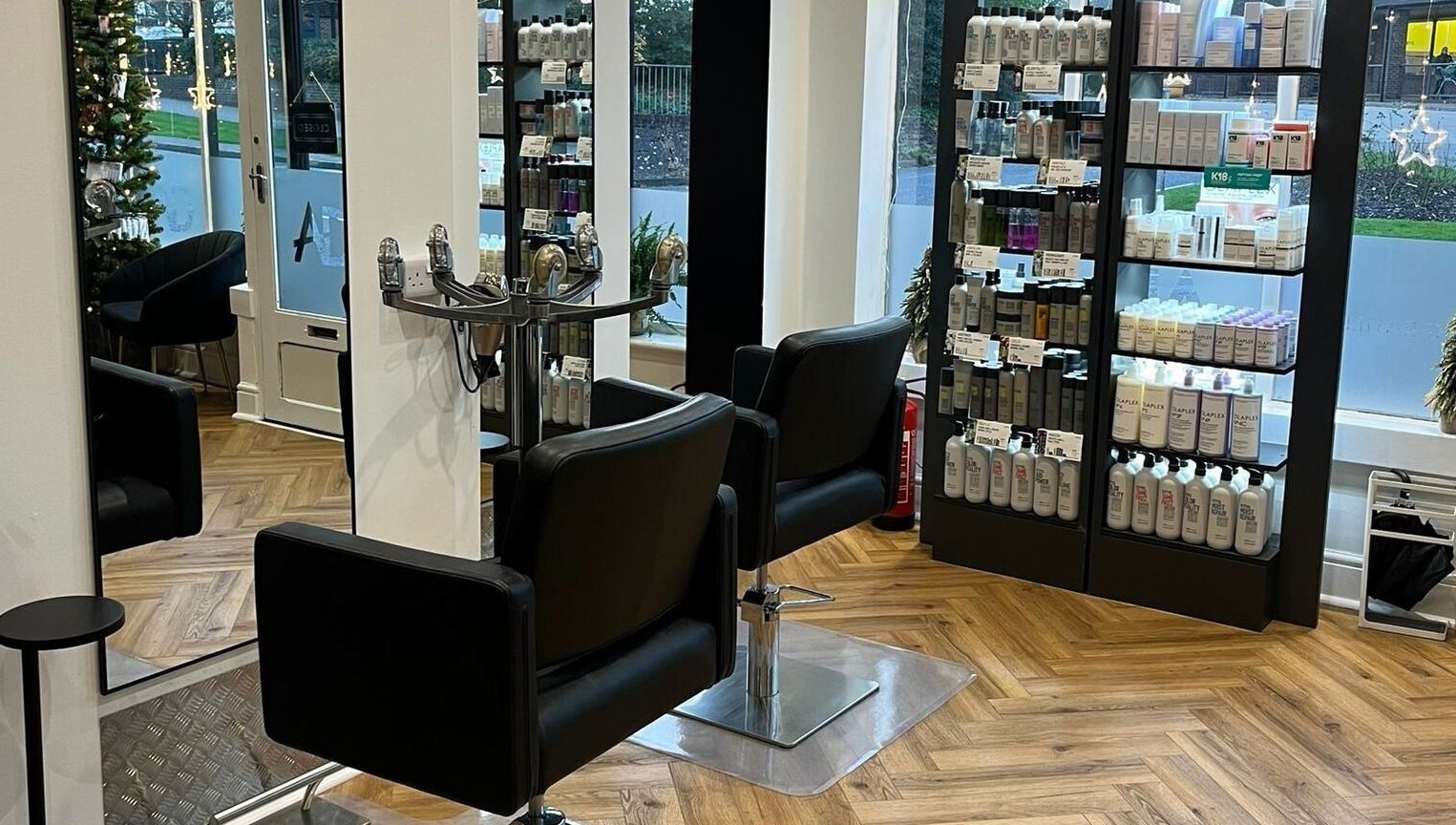 Elegant salon at Andrew David Hair, Lymington, England with sleek chairs and product display.