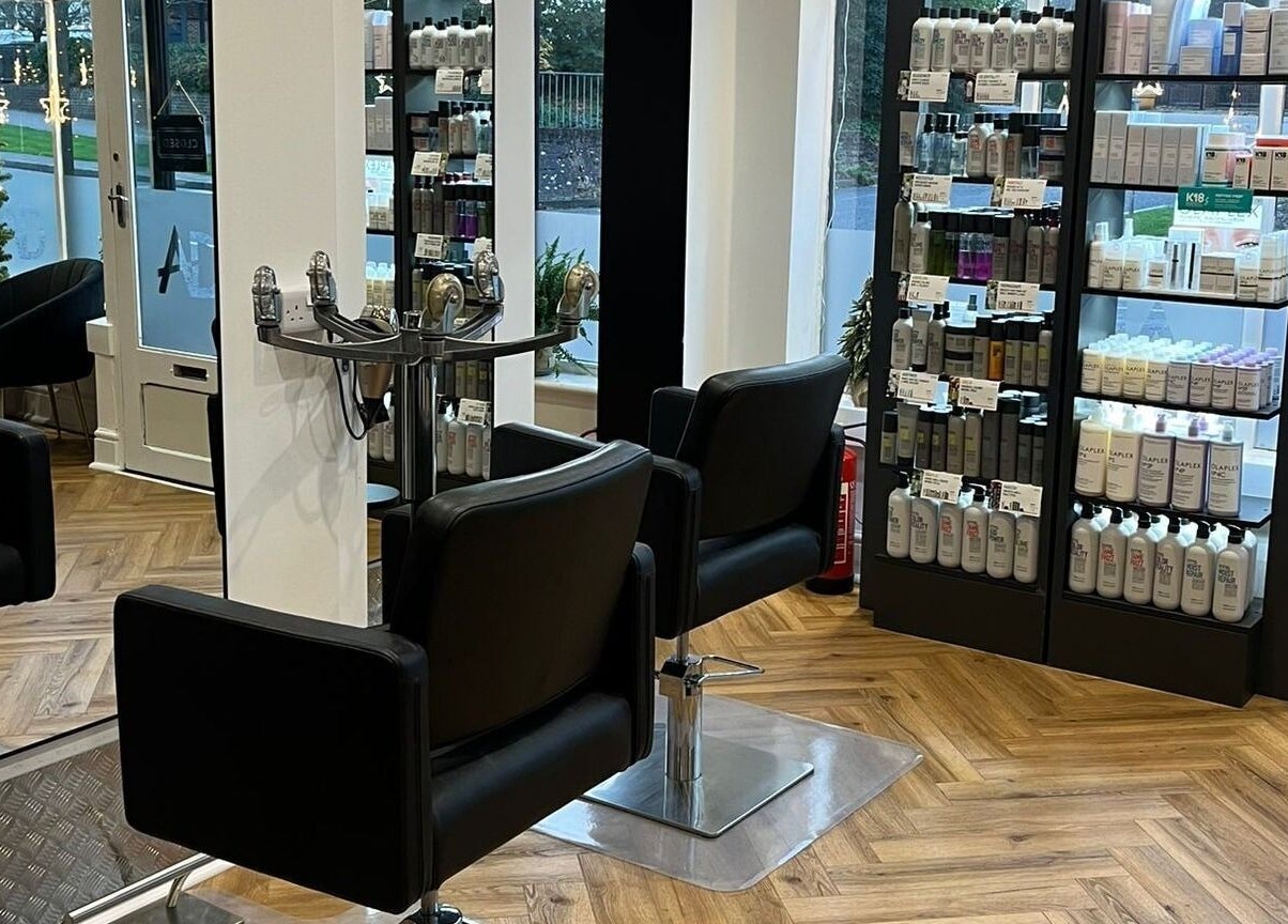 Elegant salon at Andrew David Hair, Lymington, England with sleek chairs and product display.