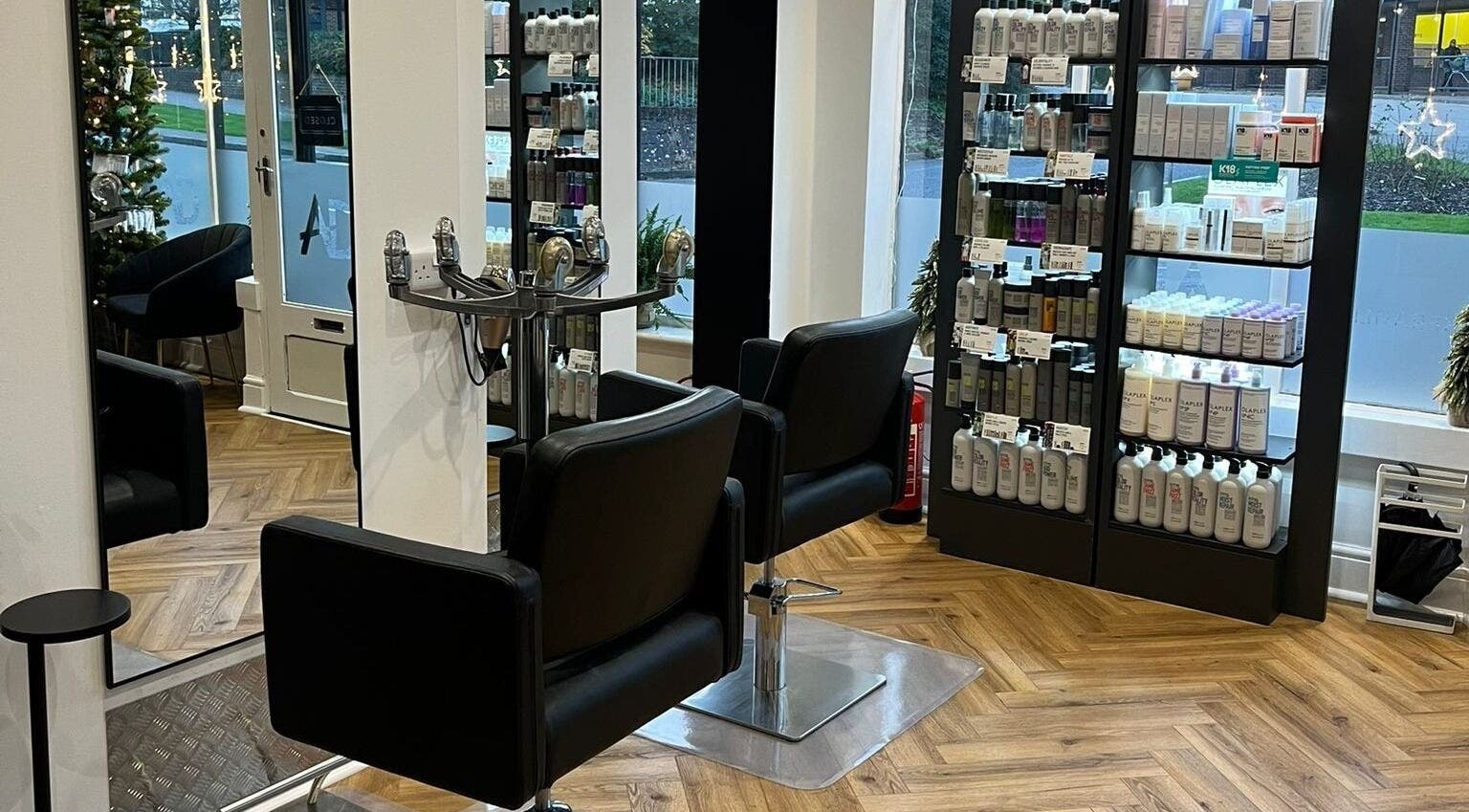 Elegant salon at Andrew David Hair, Lymington, England with sleek chairs and product display.