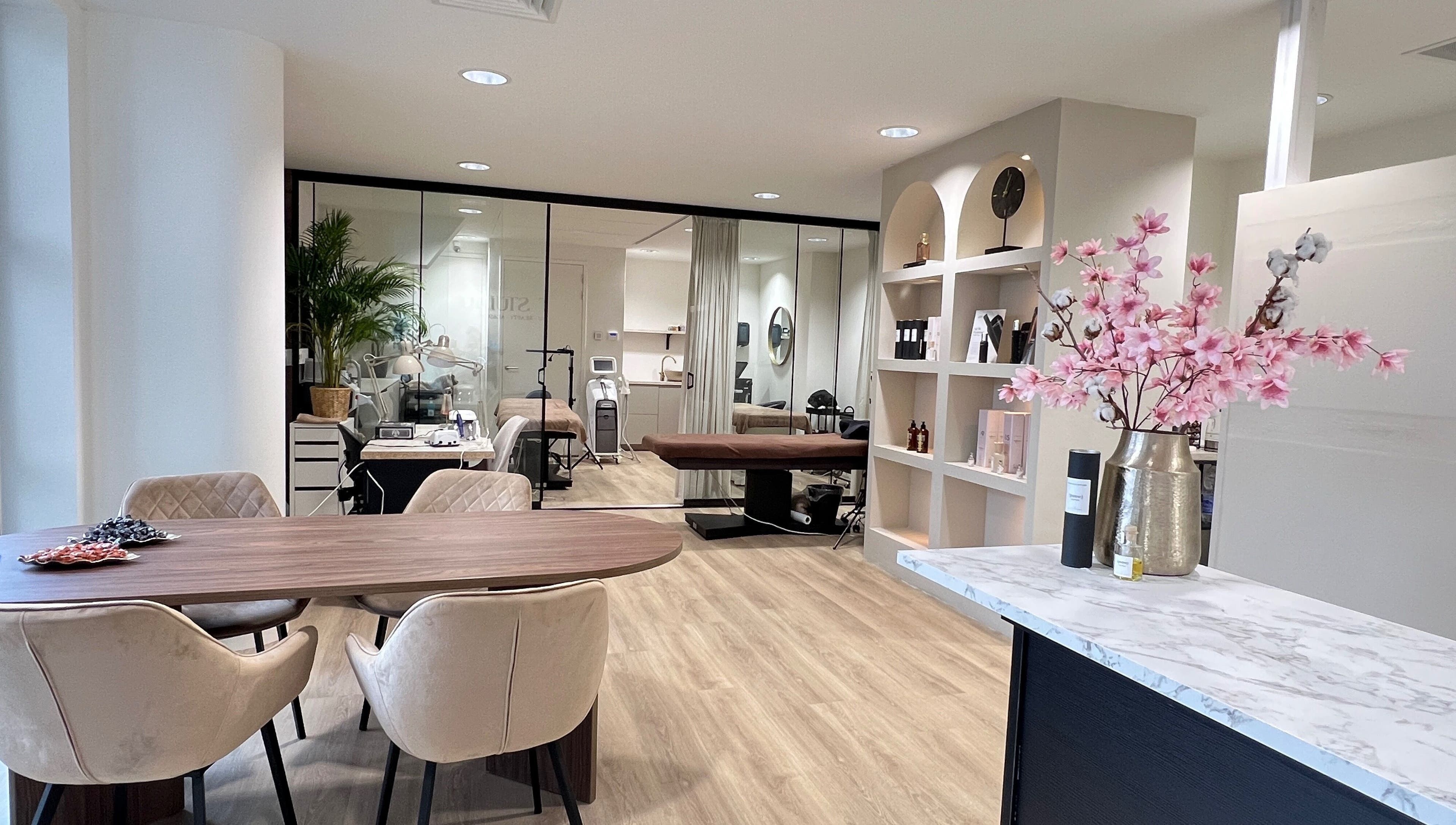 Binnenzicht van MT Studio PMU & Beauty, Amstelveen, met moderne meubels en bloemenarrangement.
