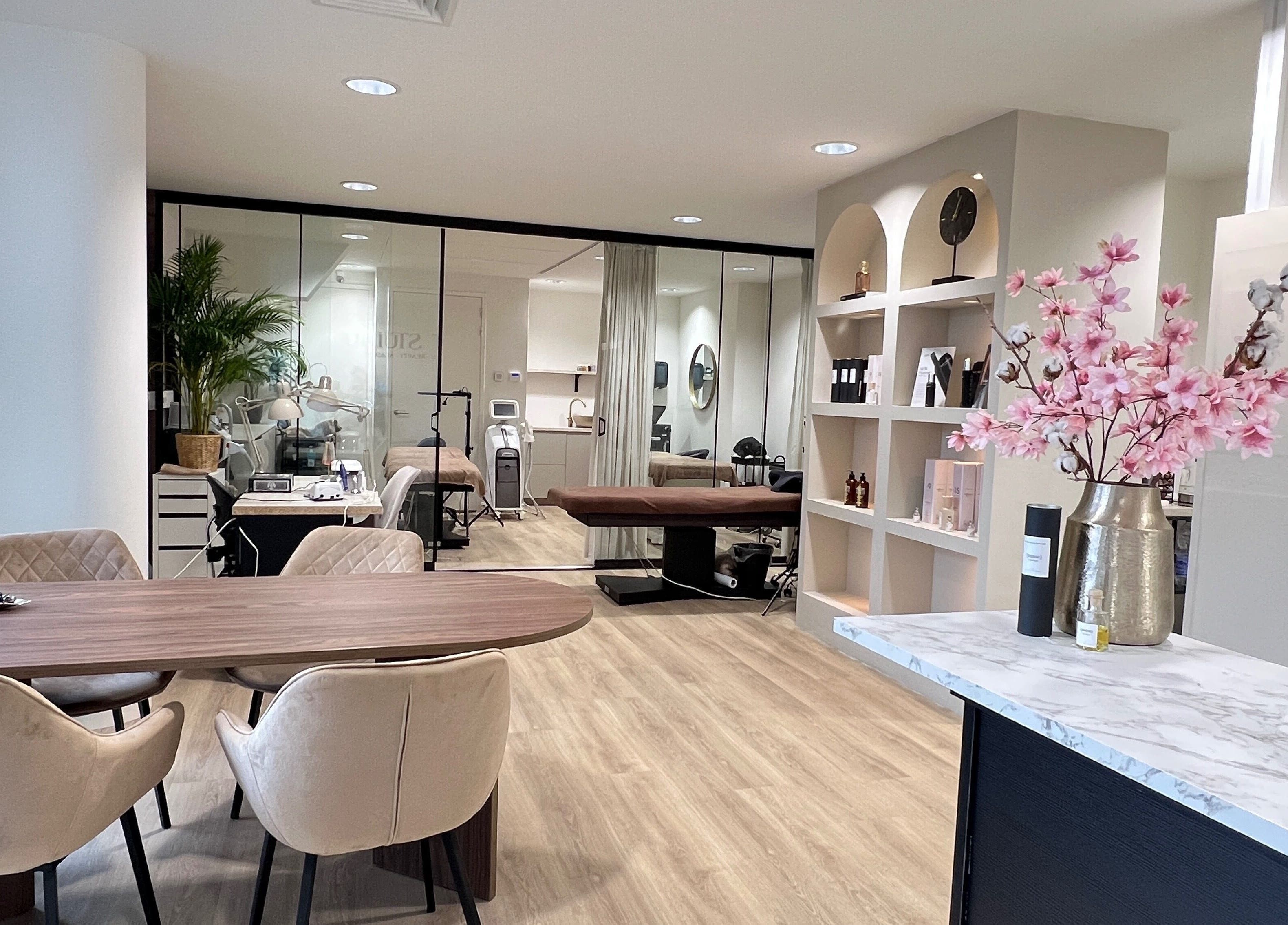 Binnenzicht van MT Studio PMU & Beauty, Amstelveen, met moderne meubels en bloemenarrangement.