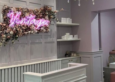 Elegant salon interior at Vintage, Salford, England, GB with soft pink hues and floral decor.