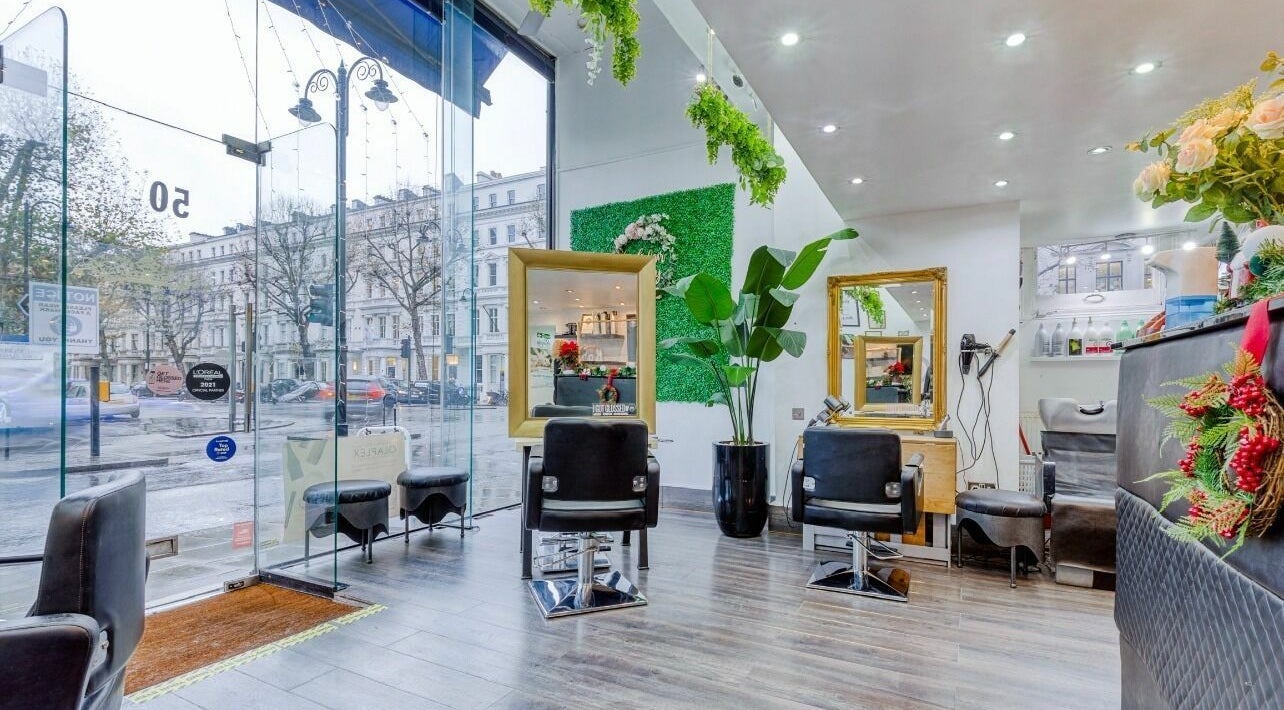 Modern interior of Chelsea Hair and Skin Clinic By Karda, London. Elegant salon setup with large mirrors and vibrant decor.