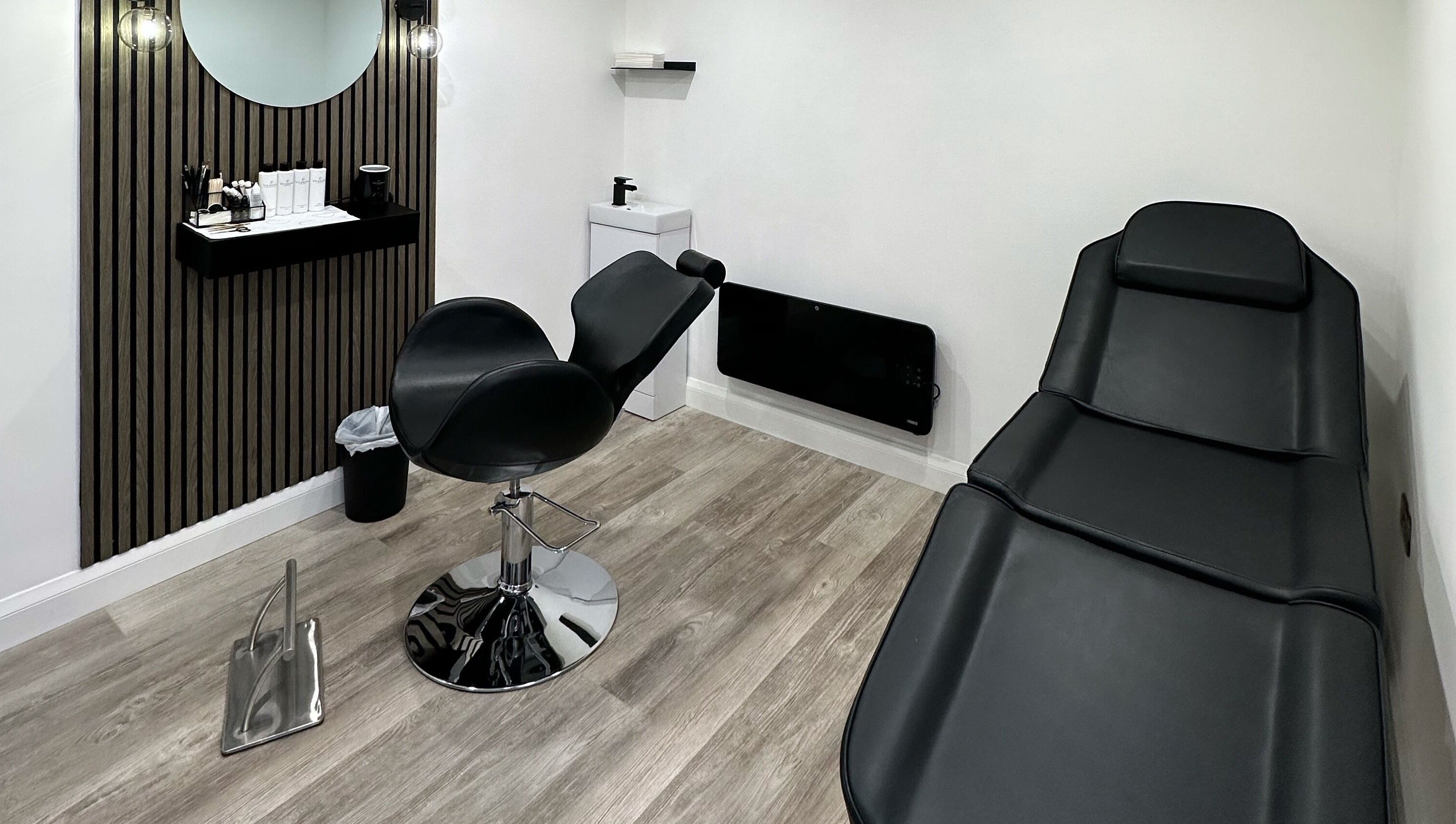 Modern treatment room at The Brow Bar, Goole, England, GB with sleek black chairs and minimalist décor.