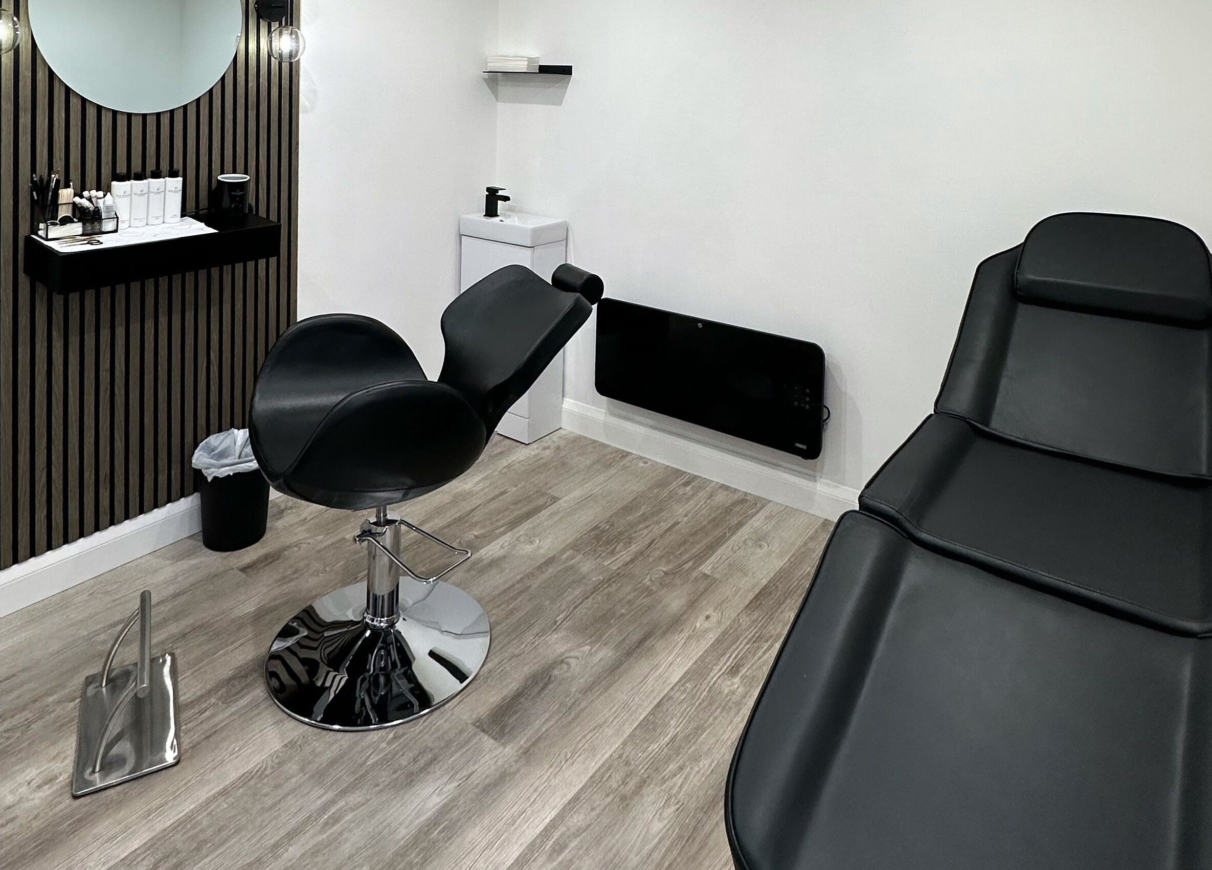 Modern treatment room at The Brow Bar, Goole, England, GB with sleek black chairs and minimalist décor.