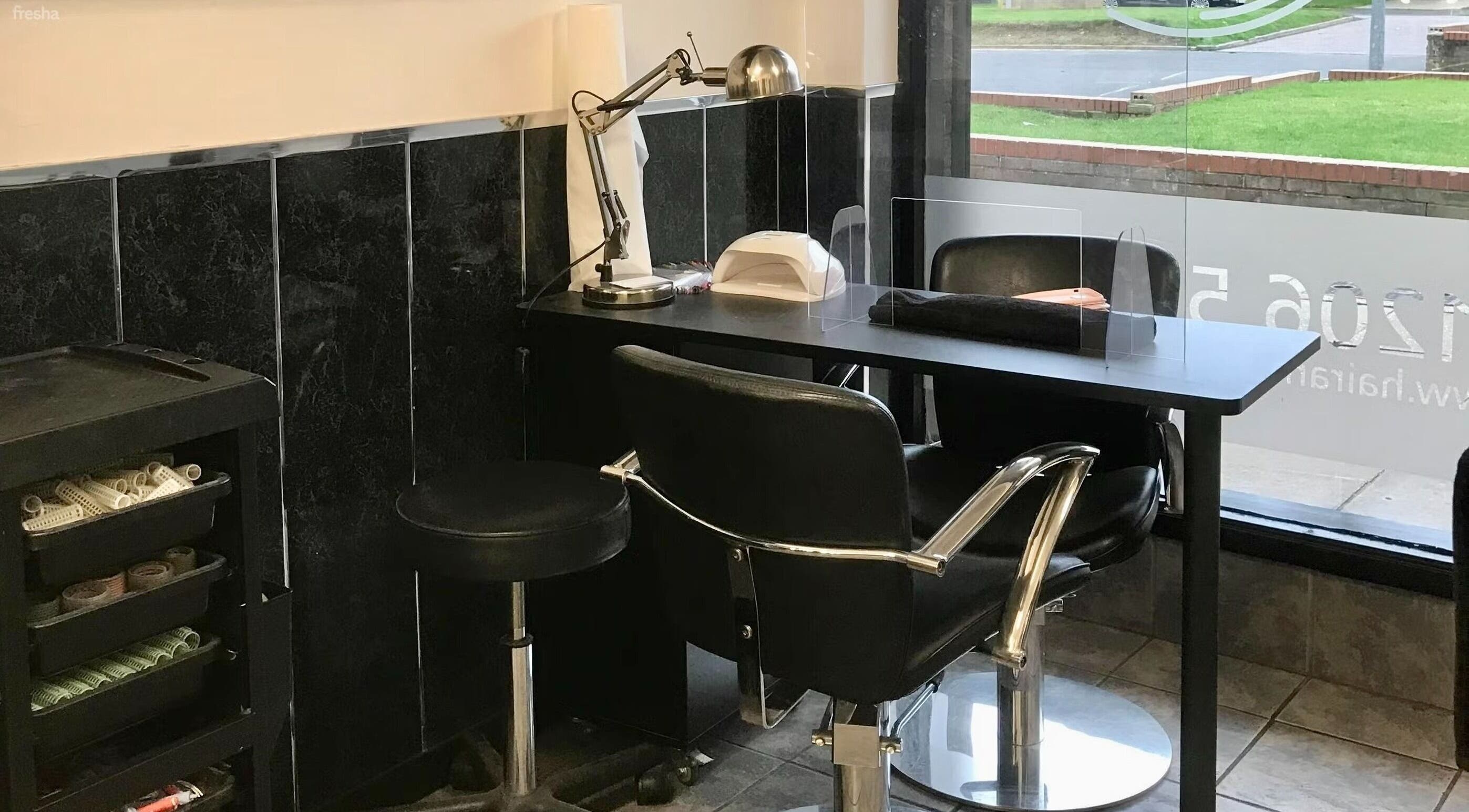 Modern nail station at Hair and Body in Colchester, England, GB, featuring sleek black chairs and manicure tools.