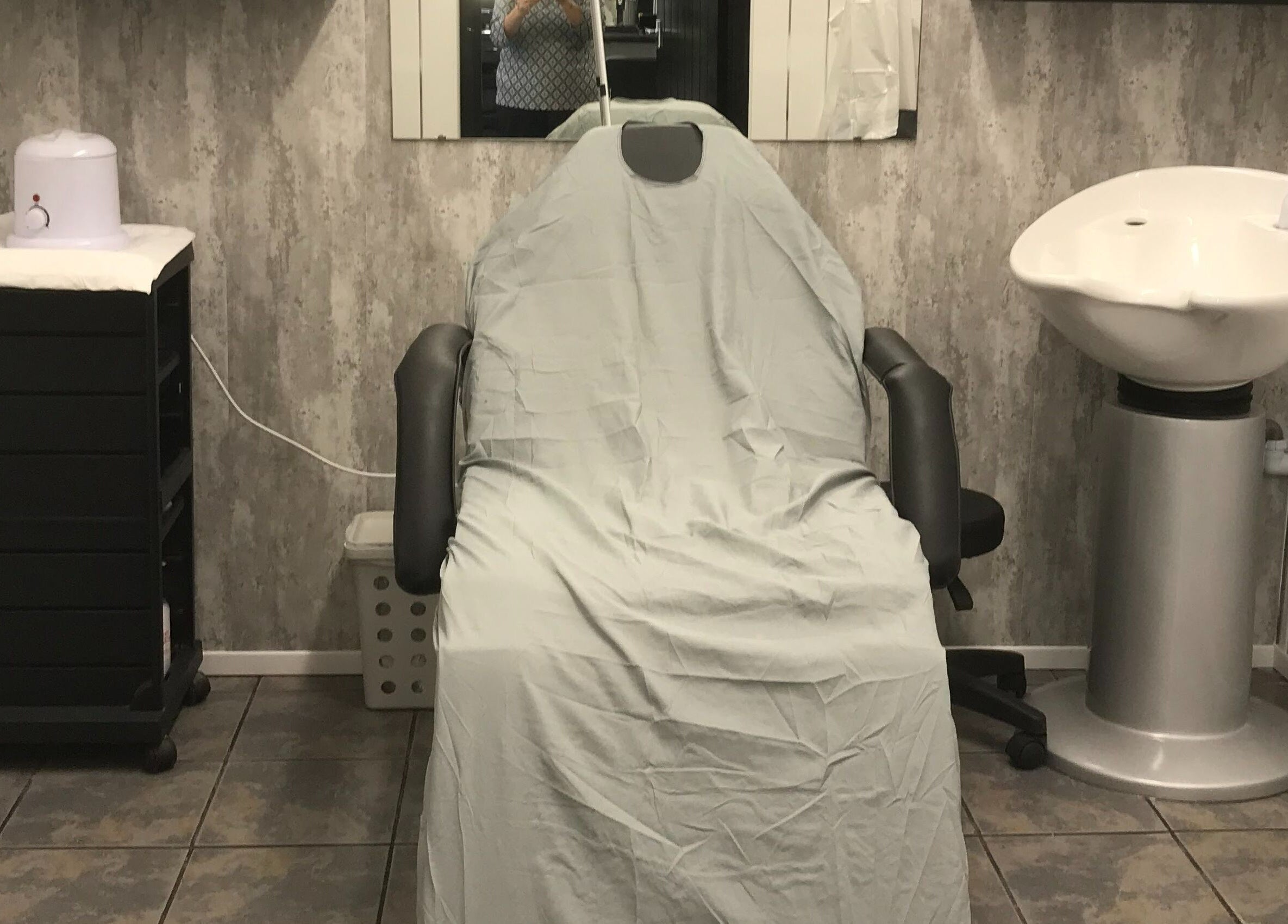 Treatment chair and sink at Hair and Body, Colchester, England, GB offering a calm stylistic setup.