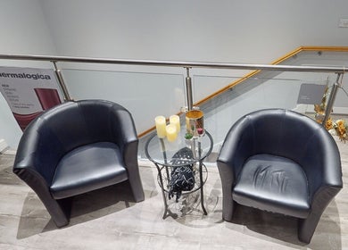 Elegant seating area at The Boutique in Knowle, England, GB, featuring two black chairs and a glass table.