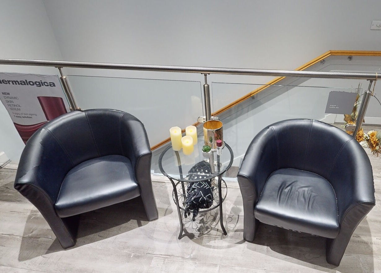 Elegant seating area at The Boutique, Knowle, England, GB, featuring leather chairs and a glass table.