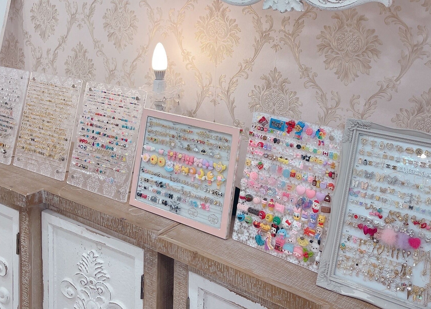 Diverse earrings at From M -Tokyo- in Toronto, Ontario, CA, elegantly displayed on a vintage cabinet.