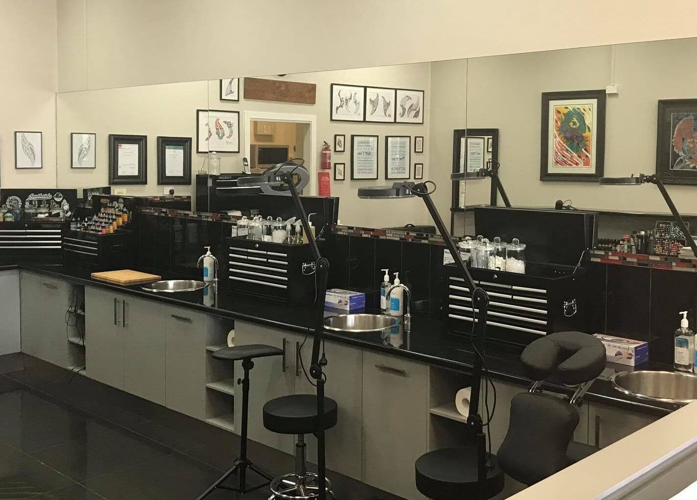 Professional tattoo studio setup at Tatauarangi Ink, Helensvale, Queensland, AU with tools and art displays.
