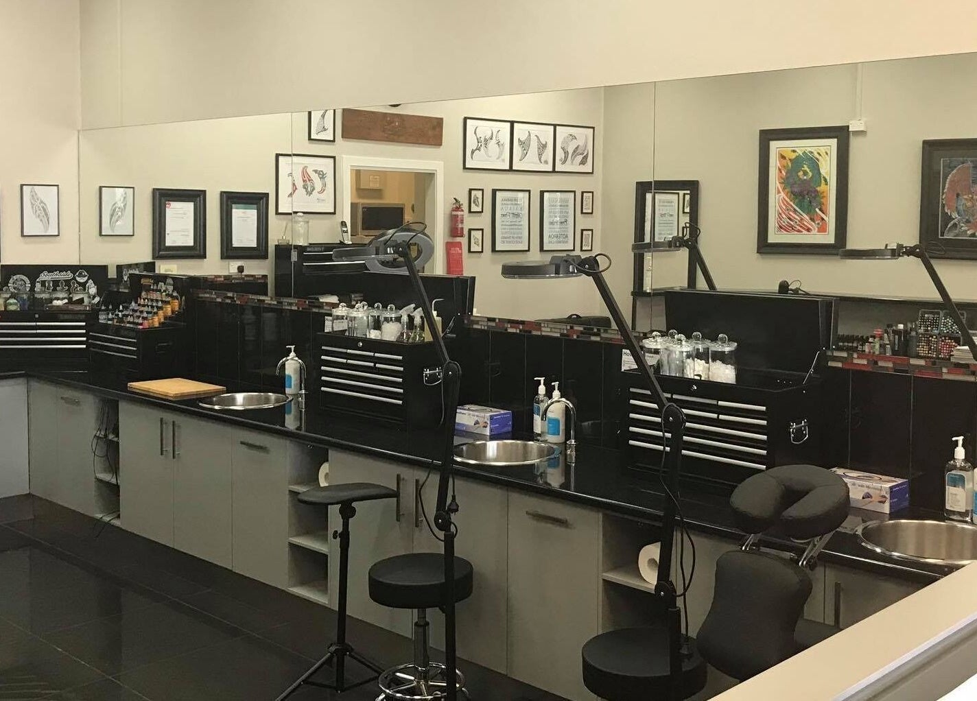 Professional tattoo studio setup at Tatauarangi Ink, Helensvale, Queensland, AU with tools and art displays.