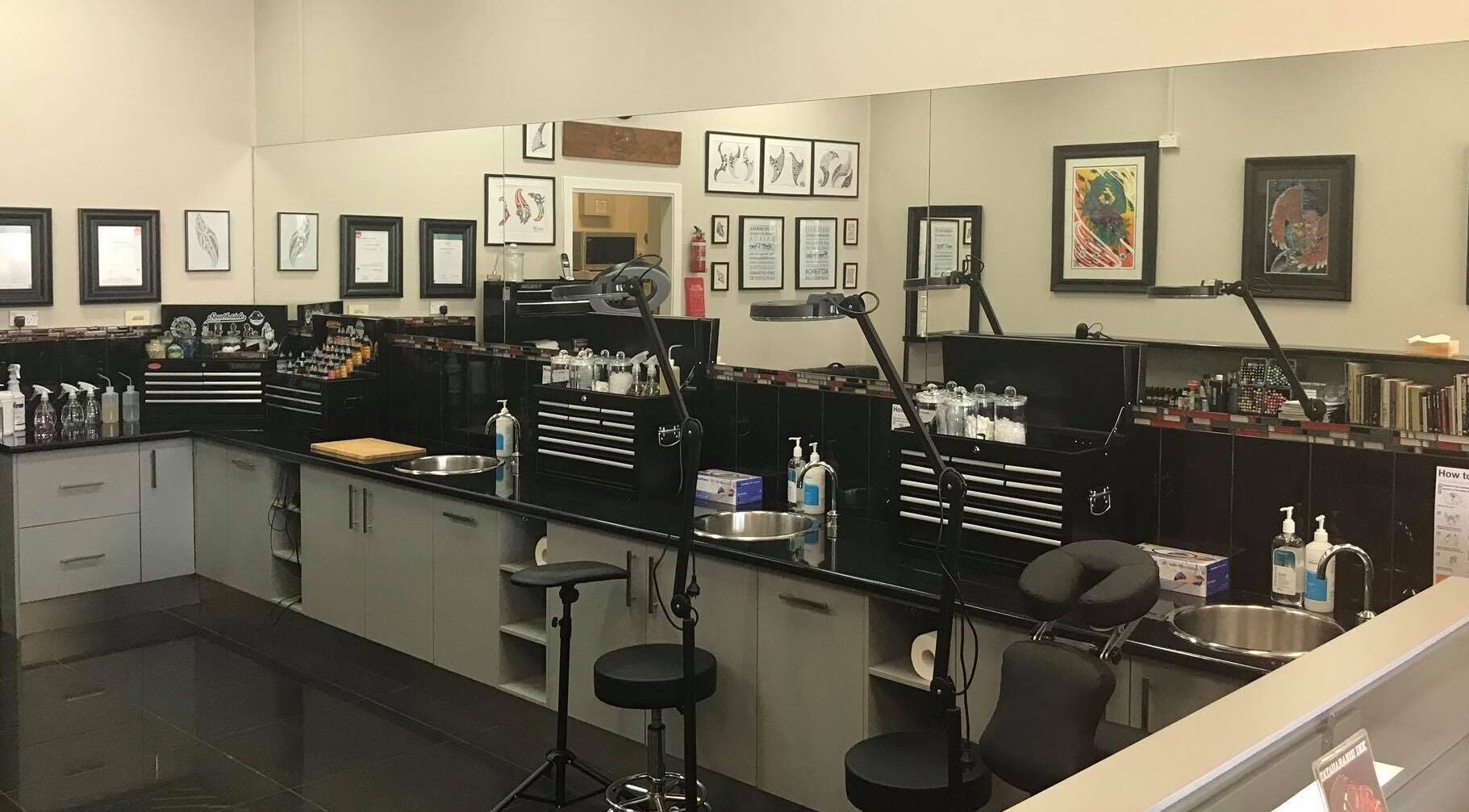 Professional tattoo studio setup at Tatauarangi Ink, Helensvale, Queensland, AU with tools and art displays.