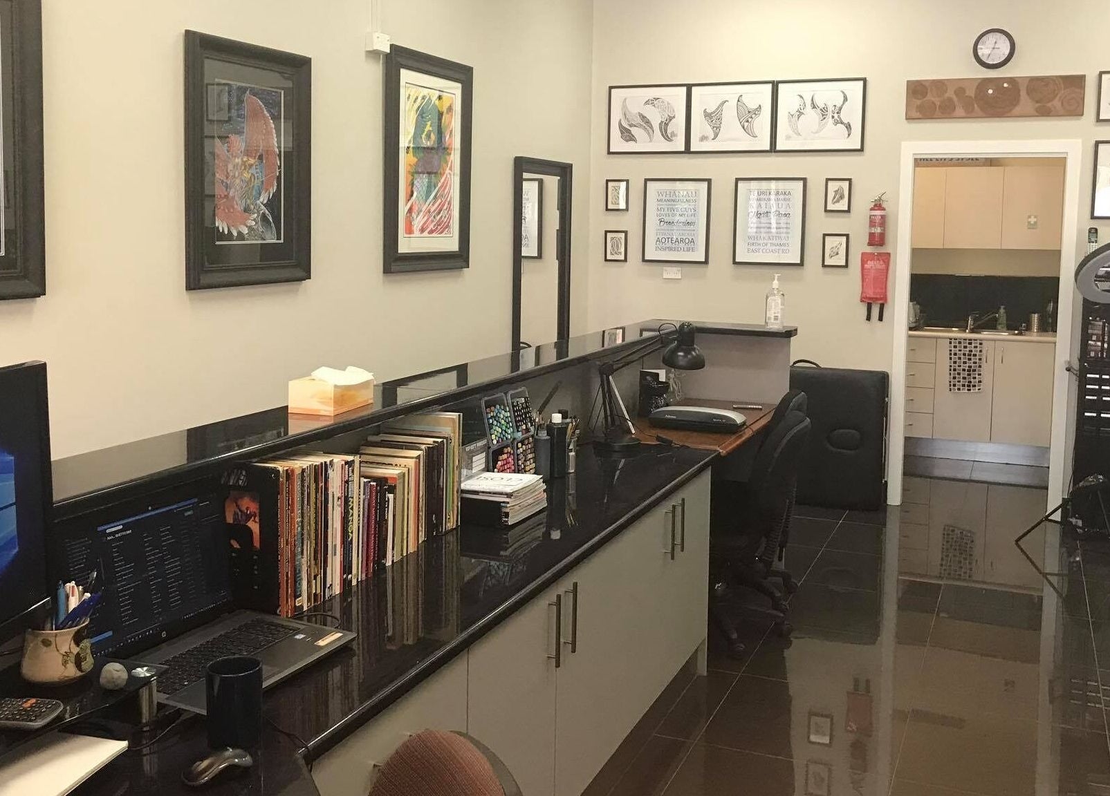 Interior of Tatauarangi Ink in Helensvale, Queensland, displaying art-filled walls and workstations.