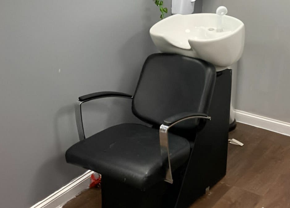 Hair wash station at Mirrors of Airdrie, Airdrie, Scotland, GB with sleek black chair and sink.