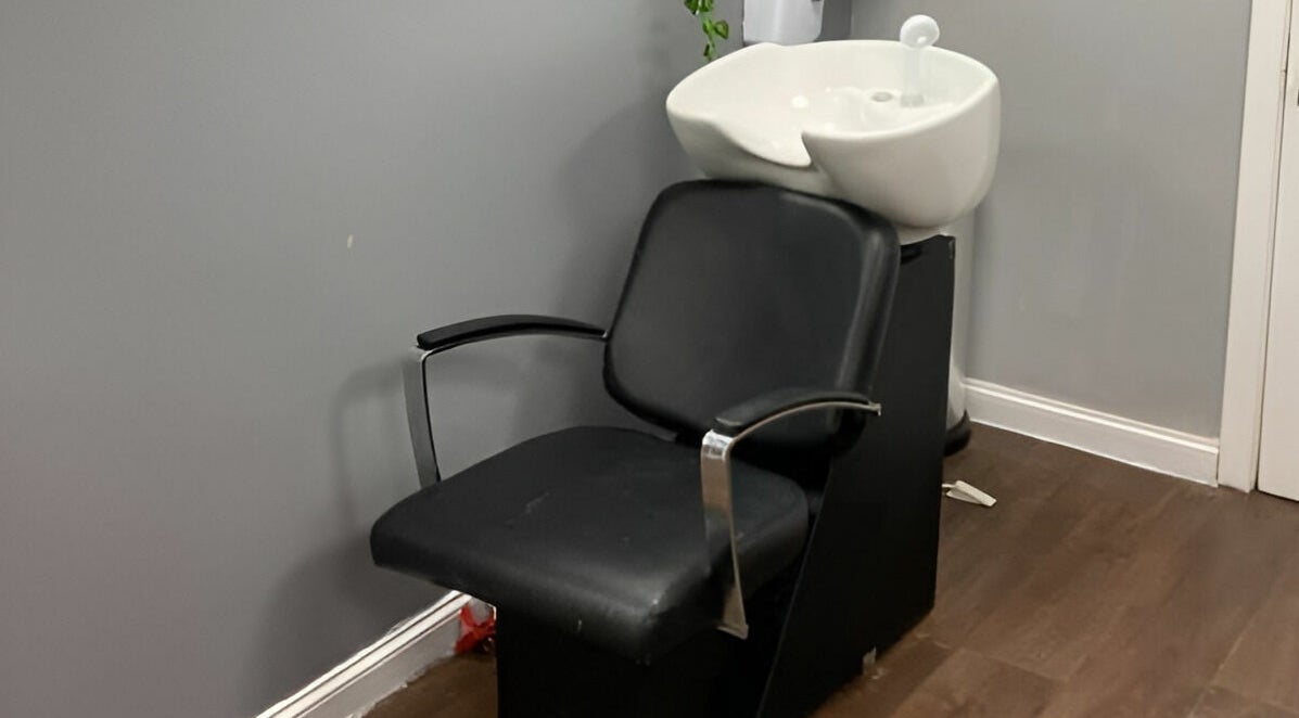 Hair wash station at Mirrors of Airdrie, Airdrie, Scotland, GB with sleek black chair and sink.